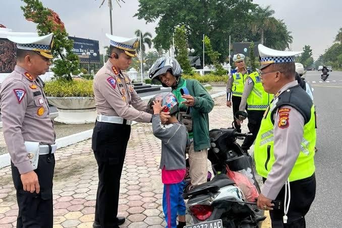 Peduli Keselamatan, Polda Riau Bagikan Helm ke Pengendara