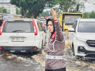 Momen Polwan Ajak Warga Tutupi Lubang di Genangan Banjir Rohil